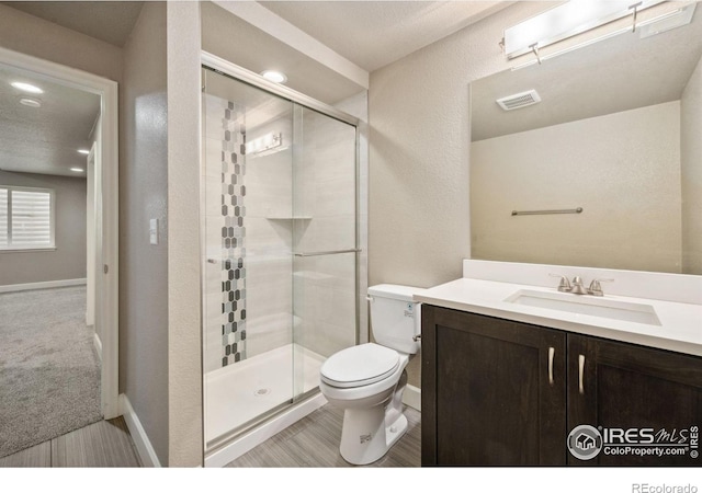 6071 Moran Rd, Timnath, CO 80547 - full bath with a stall shower, toilet, vanity, baseboards, and a textured wall
