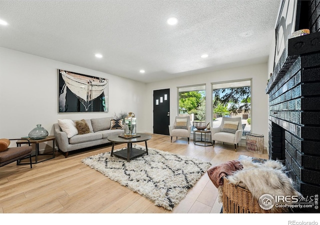 1832 24th Avenue Pl, Greeley, CO 80634 - living room with recessed lighting, a textured ceiling, a brick fireplace, and wood finished floors