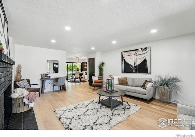 1832 24th Avenue Pl, Greeley, CO 80634 - living room with wood finished floors, recessed lighting, a textured ceiling, and a brick fireplace