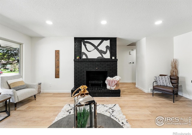 1832 24th Avenue Pl, Greeley, CO 80634 - living area with wood finished floors, a textured ceiling, recessed lighting, baseboards, and a fireplace