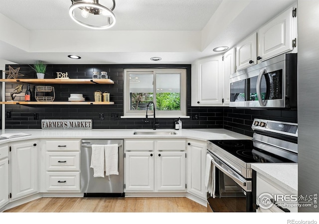 1832 24th Avenue Pl, Greeley, CO 80634 - kitchen with appliances with stainless steel finishes, a sink, open shelves, tasteful backsplash, and white cabinetry