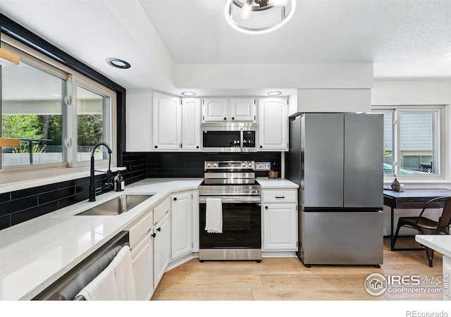 1832 24th Avenue Pl, Greeley, CO 80634 - kitchen featuring appliances with stainless steel finishes, a sink, white cabinets, and backsplash