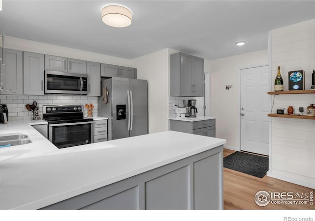 2940 E Yarrow Cir, Superior, CO 80027 - kitchen with appliances with stainless steel finishes, gray cabinetry, light wood finished floors, tasteful backsplash, and recessed lighting