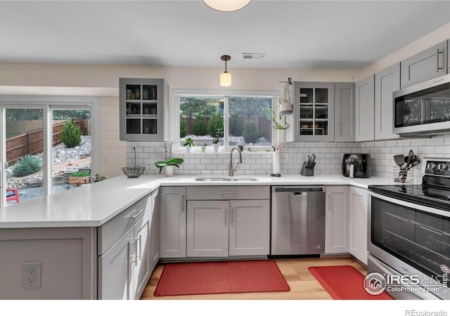 2940 E Yarrow Cir, Superior, CO 80027 - kitchen featuring stainless steel appliances, a sink, gray cabinets, a peninsula, and light countertops