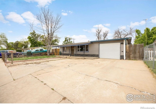 405 16th Ave, Greeley, CO 80631 - view of front of property featuring a garage, concrete driveway, and stone siding