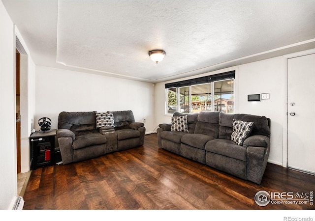 405 16th Ave, Greeley, CO 80631 - living area with wood finished floors, baseboard heating, and a textured ceiling