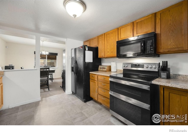 405 16th Ave, Greeley, CO 80631 - kitchen with black appliances, light countertops, and brown cabinetry