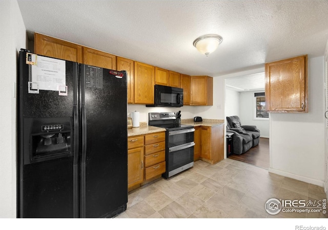 405 16th Ave, Greeley, CO 80631 - kitchen featuring black appliances, light countertops, brown cabinets, baseboards, and a textured ceiling
