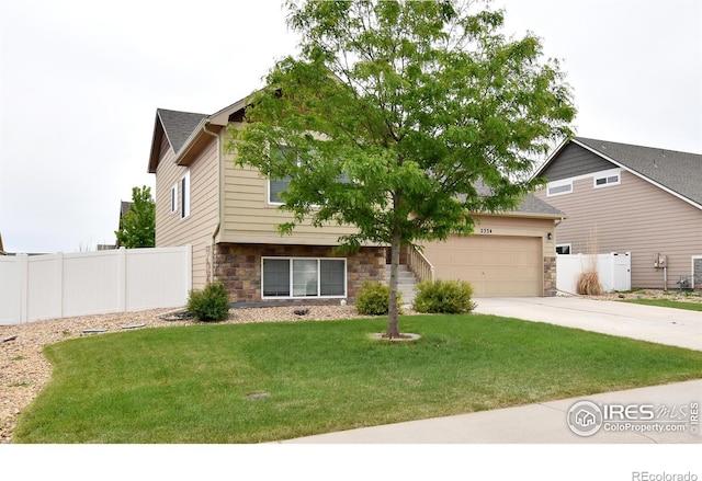 2334 75th Ave, Greeley, CO 80634 - view of front of property with stone siding, driveway, and an attached garage