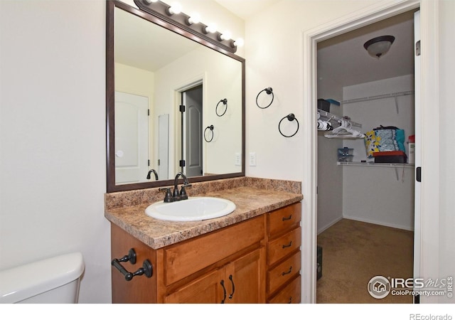 2334 75th Ave, Greeley, CO 80634 - bathroom with toilet, vanity, and a spacious closet