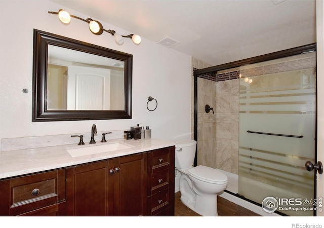 2334 75th Ave, Greeley, CO 80634 - bathroom featuring vanity, a stall shower, toilet, and wood finished floors
