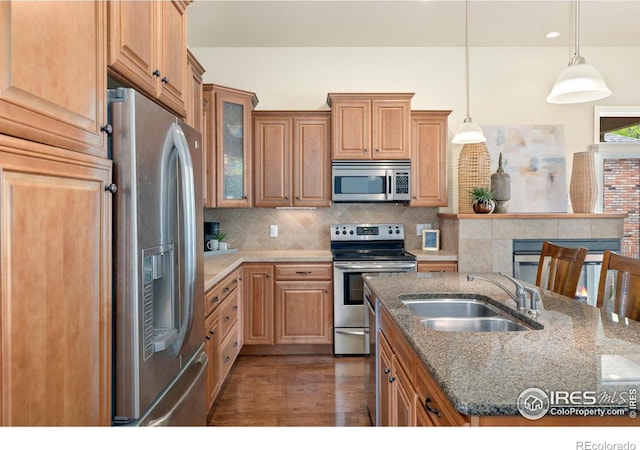 8245 Hidden Cove Ct, Windsor, CO 80528 - kitchen with appliances with stainless steel finishes, a sink, stone countertops, dark wood-style flooring, and tasteful backsplash