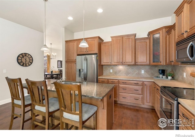 8245 Hidden Cove Ct, Windsor, CO 80528 - kitchen featuring stainless steel appliances, backsplash, a breakfast bar, dark wood-style floors, and recessed lighting