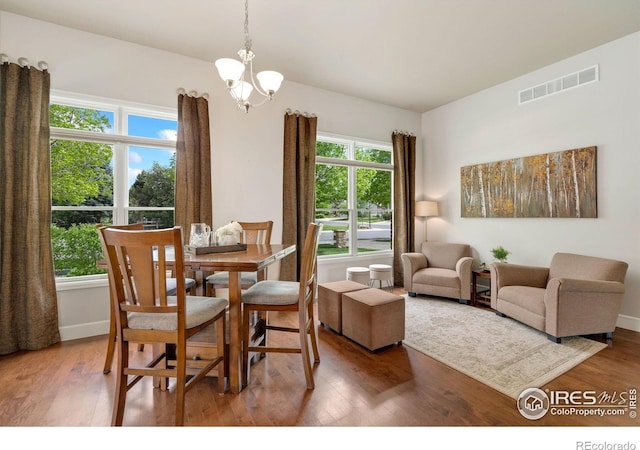 8245 Hidden Cove Ct, Windsor, CO 80528 - dining space featuring wood finished floors, a chandelier, and baseboards
