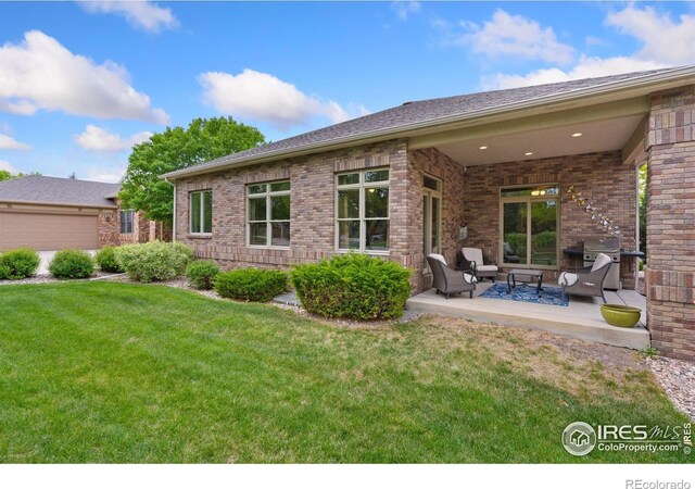 8245 Hidden Cove Ct, Windsor, CO 80528 - back of house with an outdoor hangout area, a lawn, brick siding, and a patio area