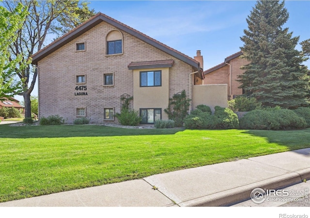 4475 Laguna Pl Unit 201, Boulder, CO 80303 - view of side of home with a yard, brick siding, and a chimney