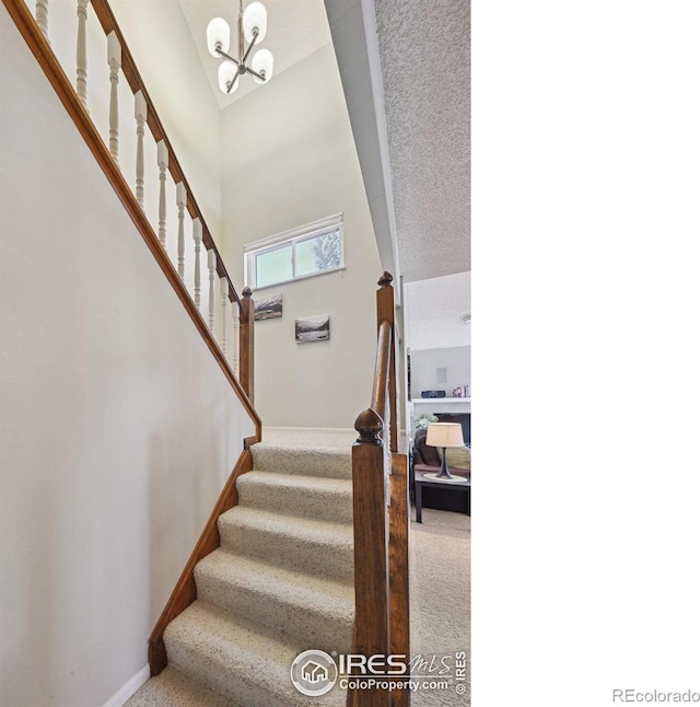 4475 Laguna Pl Unit 201, Boulder, CO 80303 - staircase with baseboards, a chandelier, carpet flooring, and a towering ceiling