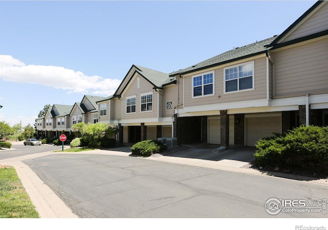 2162 Concord Ln, Superior, CO 80027 - townhome / multi-family property with a garage, brick siding, a residential view, driveway, and cooling unit