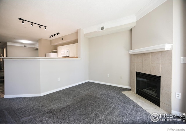 2162 Concord Ln, Superior, CO 80027 - unfurnished living room featuring carpet floors, track lighting, ornamental molding, a tile fireplace, and baseboards
