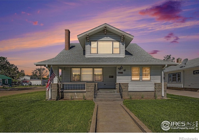 501 Adams Ave, Akron, CO 80720 - bungalow featuring covered porch, a yard, a chimney, and roof with shingles