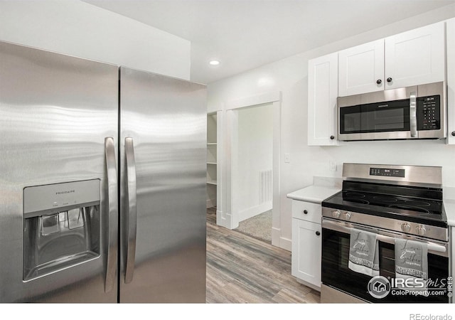 501 Adams Ave, Akron, CO 80720 - kitchen with stainless steel appliances, light wood-type flooring, white cabinets, recessed lighting, and light countertops