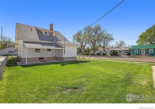 501 Adams Ave, Akron, CO 80720 - back of property with a chimney, a patio, and roof with shingles