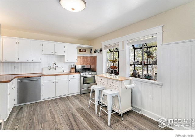 37495 County Road 27, Eaton, CO 80615 - kitchen with appliances with stainless steel finishes, a sink, light wood-type flooring, and white cabinets