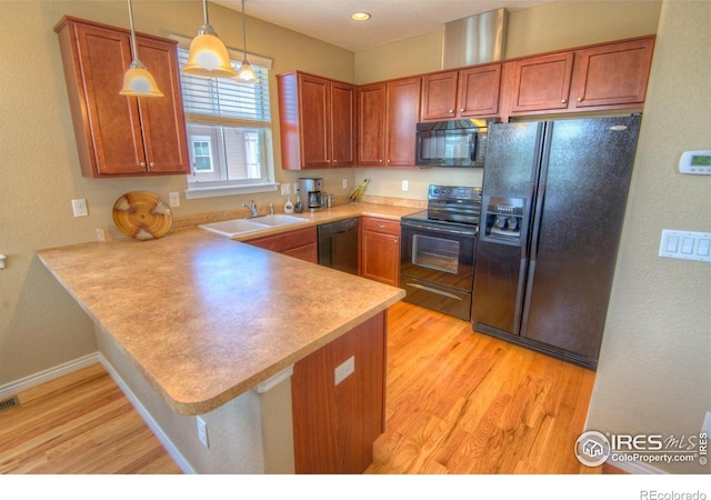 705 Rawlins Way, Lafayette, CO 80026 - kitchen with black appliances, a sink, a peninsula, light wood-style floors, and light countertops
