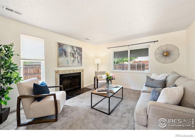 1215 Centaur Cir Unit A, Lafayette, CO 80026 - carpeted living room with a textured ceiling, a tile fireplace, and baseboards