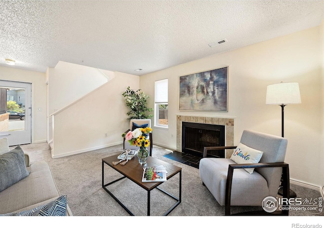 1215 Centaur Cir Unit A, Lafayette, CO 80026 - carpeted living area with a textured ceiling, a tile fireplace, and baseboards