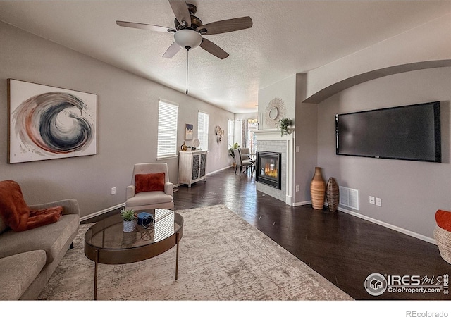 2190 Winding Dr, Longmont, CO 80504 - living area featuring a ceiling fan, wood finished floors, a fireplace, and a textured ceiling