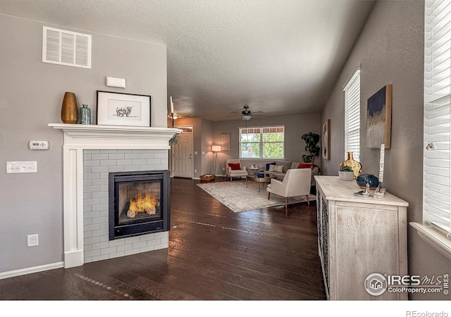 2190 Winding Dr, Longmont, CO 80504 - living room with dark wood-type flooring, a ceiling fan, a fireplace, and a textured ceiling