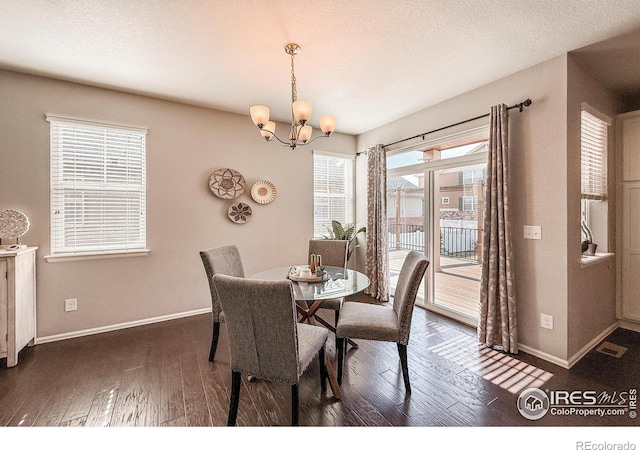 2190 Winding Dr, Longmont, CO 80504 - dining area with a chandelier, dark wood-style flooring, and a textured ceiling