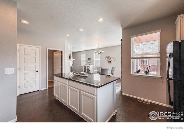 2190 Winding Dr, Longmont, CO 80504 - kitchen featuring a chandelier, recessed lighting, a kitchen island, freestanding refrigerator, and white cabinets