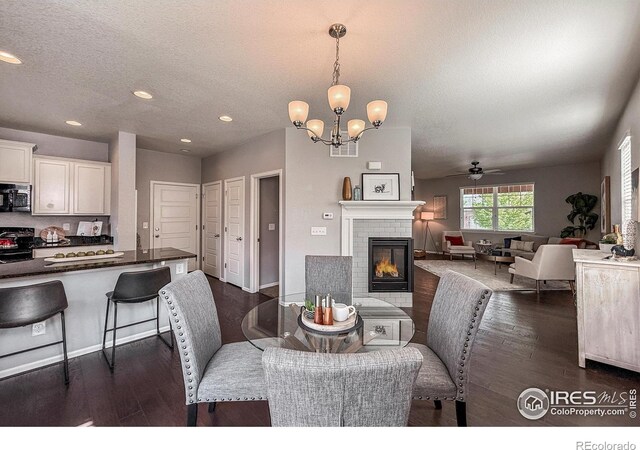 2190 Winding Dr, Longmont, CO 80504 - dining room with dark wood finished floors, recessed lighting, a ceiling fan, a chandelier, and a textured ceiling