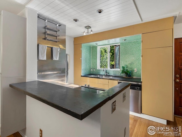 3345 Hickok Pl, Boulder, CO 80301 - kitchen with dark countertops, stovetop, stainless steel dishwasher, a sink, and light wood-style floors