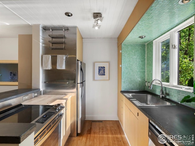 3345 Hickok Pl, Boulder, CO 80301 - kitchen featuring stainless steel appliances, a sink, light wood-style flooring, dark countertops, and baseboards