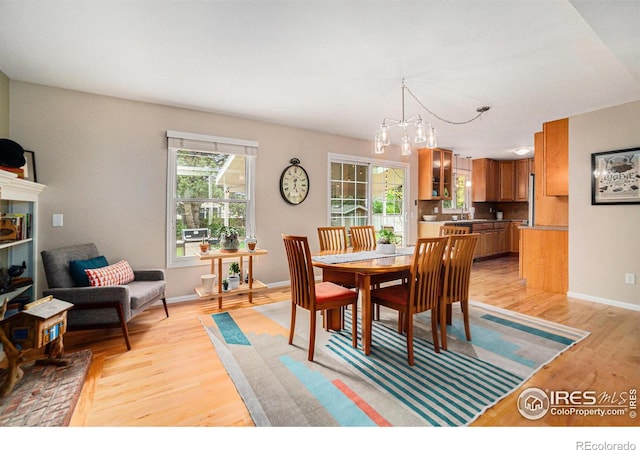 1119 Oakmont Ct, Fort Collins, CO 80525 - dining area featuring light wood-style floors, a chandelier, and baseboards