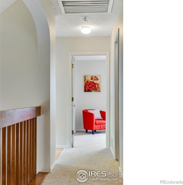 911 Homer Cir, Lafayette, CO 80026 - hall with a textured ceiling, light colored carpet, baseboards, and arched walkways