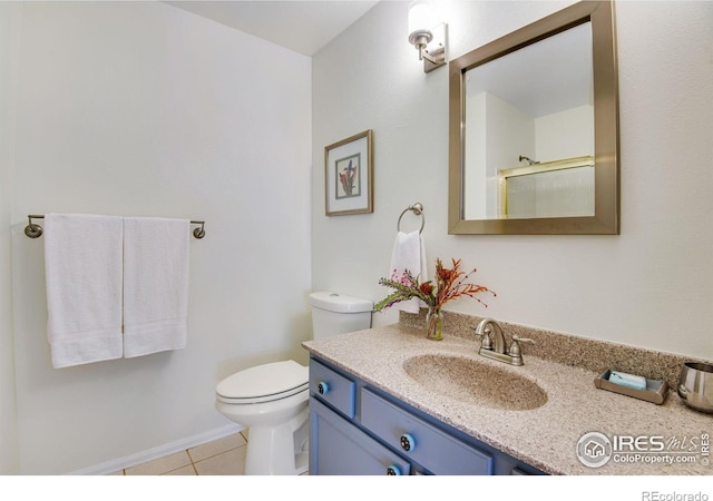 911 Homer Cir, Lafayette, CO 80026 - bathroom featuring tile patterned floors, toilet, vanity, an enclosed shower, and baseboards