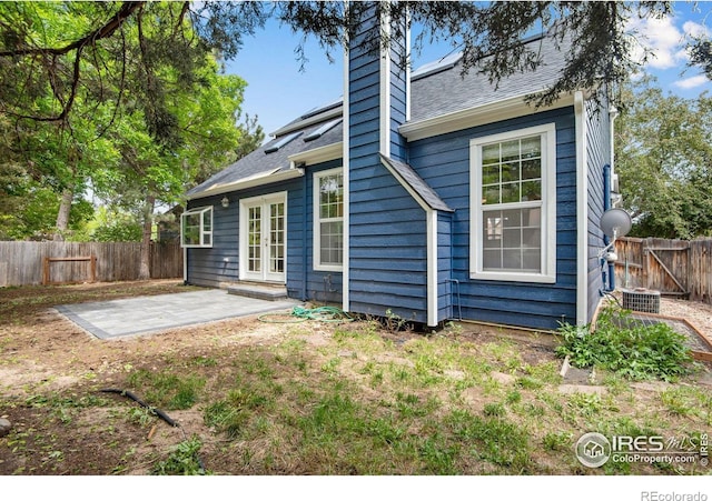 911 Homer Cir, Lafayette, CO 80026 - back of house with a patio area, a chimney, a fenced backyard, a shingled roof, and central AC unit