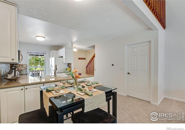 911 Homer Cir, Lafayette, CO 80026 - kitchen with stainless steel microwave, light carpet, white cabinetry, a textured ceiling, and freestanding refrigerator