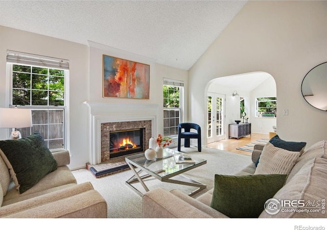 911 Homer Cir, Lafayette, CO 80026 - living room featuring arched walkways, healthy amount of natural light, a fireplace, vaulted ceiling, and a textured ceiling