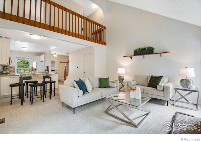 911 Homer Cir, Lafayette, CO 80026 - living area with stairs, light colored carpet, and high vaulted ceiling