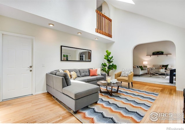 911 Homer Cir, Lafayette, CO 80026 - living room featuring arched walkways, hardwood / wood-style flooring, and high vaulted ceiling