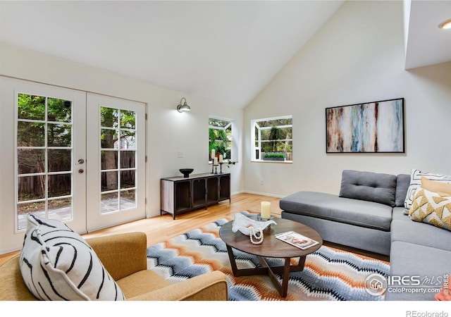 911 Homer Cir, Lafayette, CO 80026 - living room with french doors, plenty of natural light, high vaulted ceiling, light wood finished floors, and baseboards