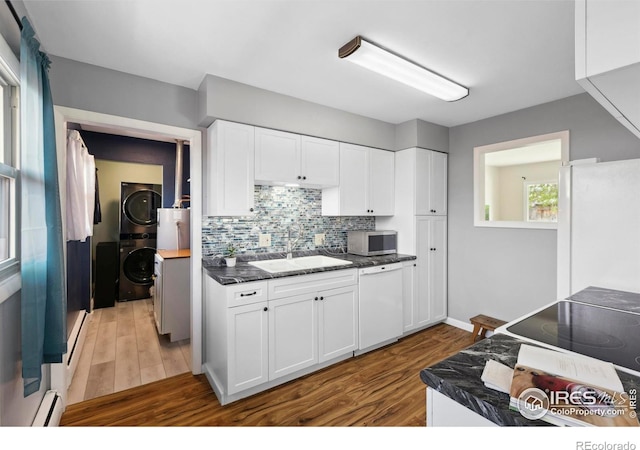 1217 N US Highway 287, Fort Collins, CO 80524 - kitchen with estacked washer and dryer, white appliances, a sink, wood finished floors, and a baseboard radiator
