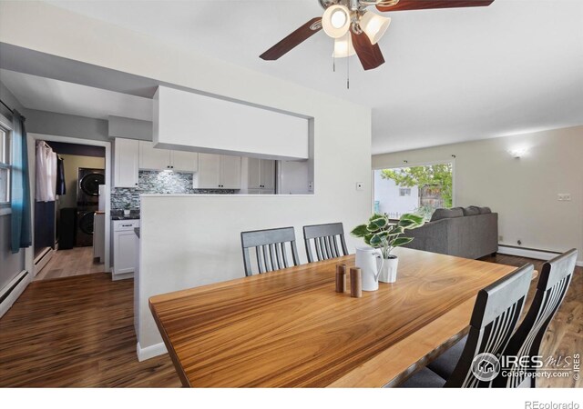 1217 N US Highway 287, Fort Collins, CO 80524 - dining space featuring stacked washing machine and dryer, wood finished floors, ceiling fan, and baseboard heating
