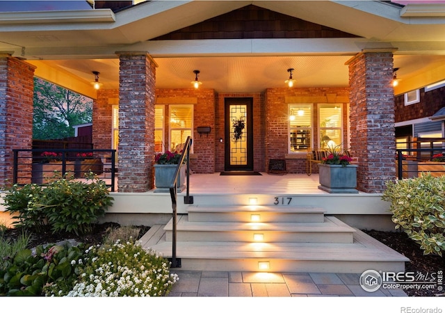 317 Wood St, Fort Collins, CO 80521 - view of exterior entry with a porch and brick siding