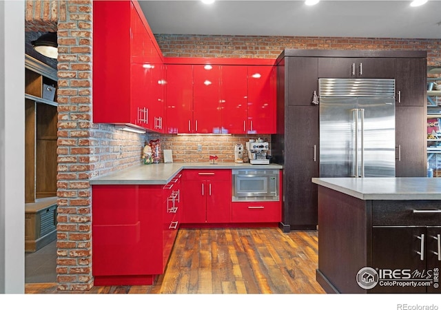 317 Wood St, Fort Collins, CO 80521 - kitchen with red cabinetry, built in appliances, dark wood finished floors, recessed lighting, and decorative backsplash